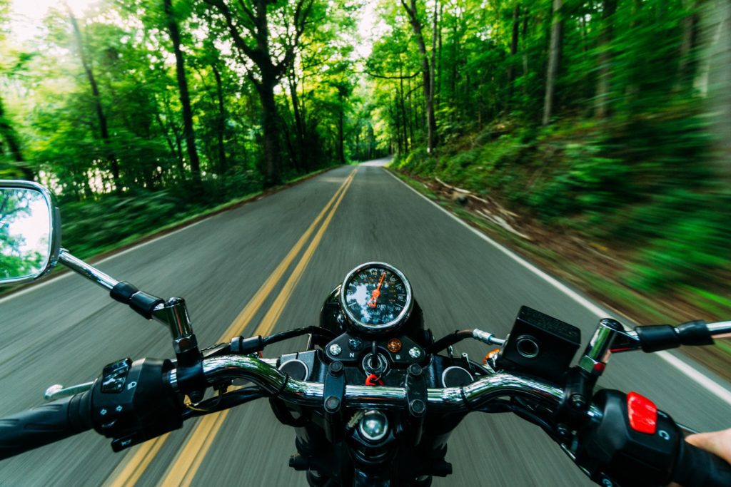 First Person View Driving a Motorcycle on a Road That Goes Though Forrest